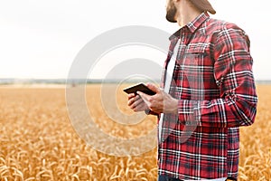 Smart farming using modern technologies in agriculture. Man agronomist farmer with digital tablet computer in wheat
