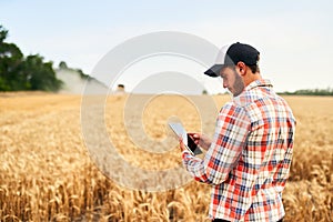 Smart farming using modern technologies in agriculture. Man agronomist farmer holding digital tablet computer standing