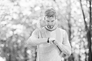 Smart fitness. Fit athlete tracking his fitness activity with sports watch. Handsome athlete using fitness tracker