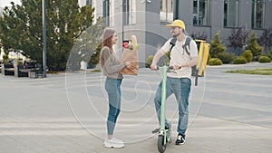 Smart food delivery service man in white uniform handing fresh food to recipient and young woman customer receiving