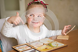 Smart girl with Down syndrome collects puzzles