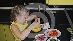 Smart girl learning to cook. Young mistress children to cook a Neapolitan egg fried omelette from salame affumicato