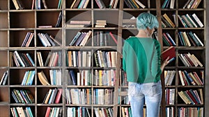 Smart girl selecting literature book in store