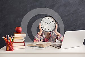 Cute smart girl holding clock covering fave