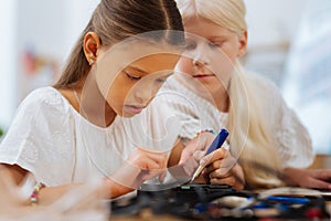 Smart girls inventing a device in a classroom