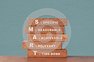 Smart goal of business strategy concept. specific, measurable, achievable, relevant and time-bound text on wooden block with photo