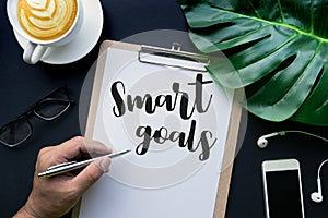 Smart goals text with hand writing on notepaper and accessories