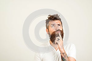 Smart handsome bearded guy having great plan or idea over white background, with copy space. Guy holding his chin and thoughtfully