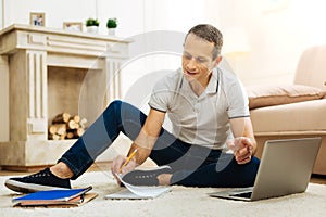 Smart handsome man feeling glad while working at home