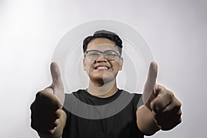 smart handsome young asian man showing thumbs up with both hands and smiling on white background