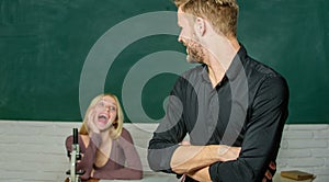 Smart and high trained. Handsome man standing hands crossed in classroom with teacher. High school student saying lesson