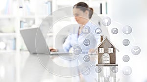 Smart home automation concept house and symbols on idesktop with woman and computer on background web banner and copy space