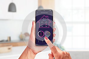 Smart home control app concept on modern phone in woman hands