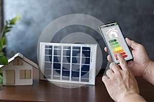 Smart home display and model house with solar panel, energy efficient technology concept. Energy efficiency mobile app on screen