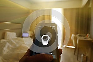 Smart Home: Man Controlling Lights With App On His Phone. electric concept.