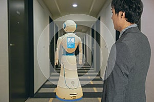 Smart hotel in hospitality industry 4.0 technology concept, robot butler robot assistant use for greet arriving guests, deliver cu