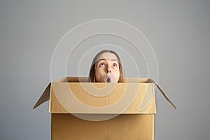 Smart idea.. Teenager student girl sitting inside cardboard box  looking up