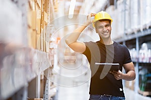 Smart Indian engineer man worker wearing safety helmet doing stocktaking of product management in cardboard box