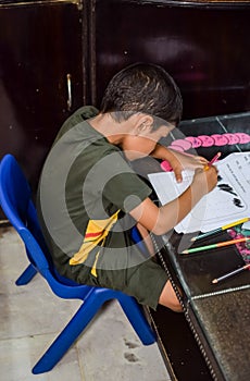 Smart Indian little boy drawing with colourful pencils kit of various colours during the summer vacations, Cute Indian Kid