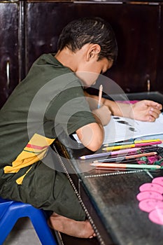 Smart Indian little boy drawing with colourful pencils kit of various colours during the summer vacations, Cute Indian Kid