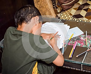 Smart Indian little boy drawing with colourful pencils kit of various colours during the summer vacations, Cute Indian Kid