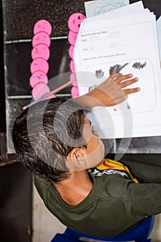 Smart Indian little boy drawing with colourful pencils kit of various colours during the summer vacations, Cute Indian Kid