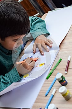 Smart Indian little boy perform thumb painting with different colourful water colour kit during the summer vacations, Cute Indian