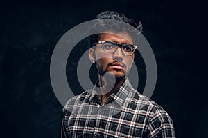 Smart Indian student wearing eyewear and a plaid shirt.