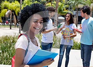 Smart latin american female student with group of students