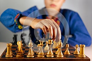 Smart little boy playing chess, a teen grandmaster with vintage chess board