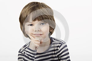 Smart little boy with serious thinking face the white background.