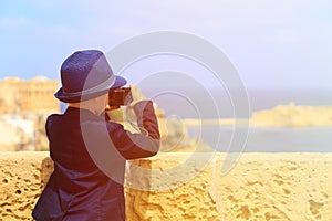 Smart little boy taking photos while travel in