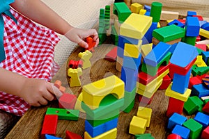 smart little child, girl 3 years old playing with educational toy, wooden geometric figures, blocks, kindergarten games, concept