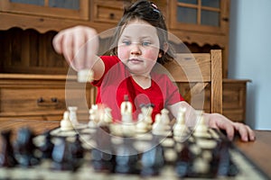 A smart little girl playing chess