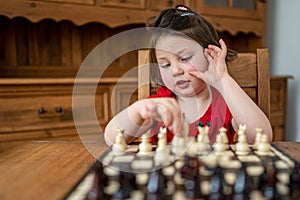 A smart little girl playing chess