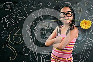 Smart little girl smiling in front of a blackboard