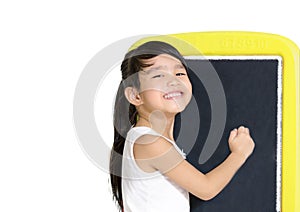 Smart little girl smiling in front of a blackboard on white background.