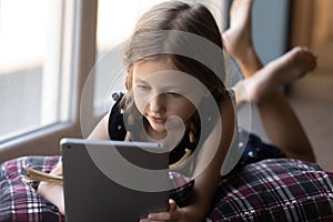 Smart little girl using modern tablet gadget