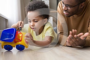 Smart little kid fix toy car playing with dad