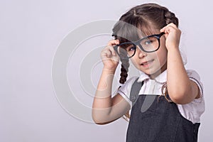 Smart little school child got a bright idea on grey background. Small girl with genius ideas.