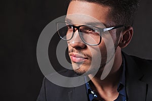smart man wearing glasses in studio background while looking away