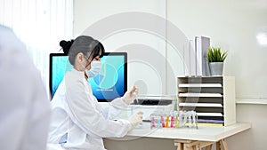 A smart Asian female chemist or scientist at her office desk in the lab