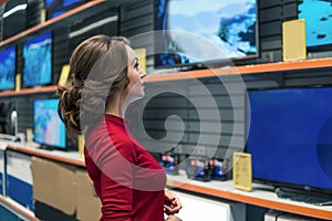 Smart modern female customer choosing large TV-sets