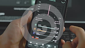 Smart money management. Using technology to track budget. A person who uses a cell phone to do their accounts. Checking