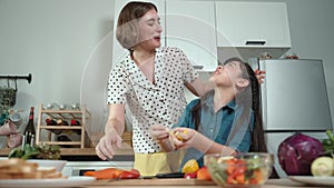 Smart mother and asian girl cooking together and chopping vegetable. Pedagogy.