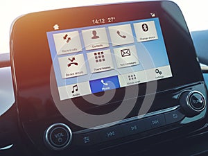 Smart multimedia in-car display with hands-free phone control. Modern navigation device on center of the car control panel