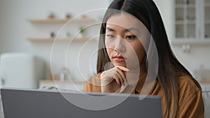 Smart pensive Asian chinese woman 30s businesswoman work from home kitchen thoughtful writer think business plan