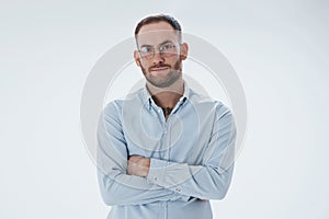 Smart person in eyewear. Man in official clothes stands against white background in the studio