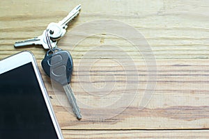 Smart phone, car remote key and keys on the wooden background