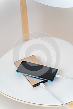 Smart phone charging with charger power bank on white chair